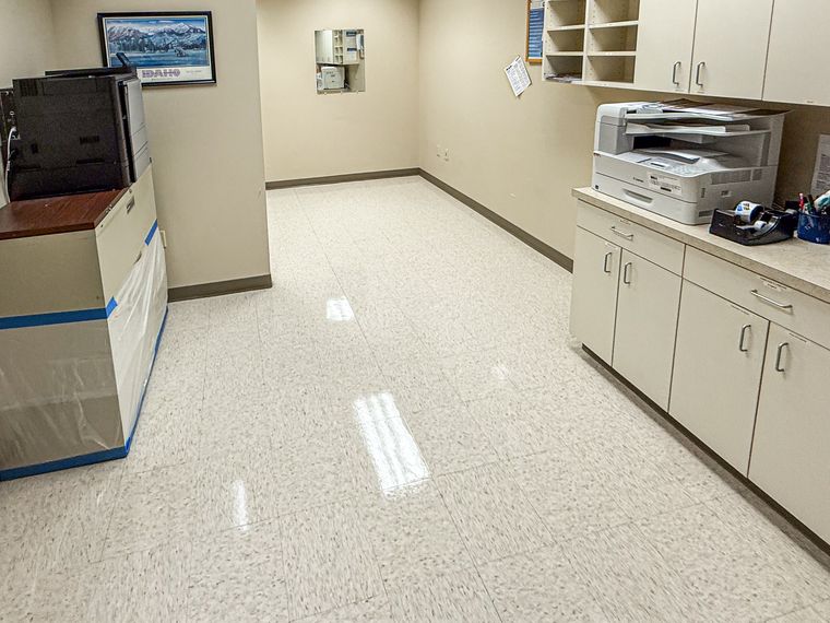 The same copy room floor after stripping and waxing, with a clean even shine